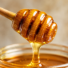 Honey Dipper with Pure Forest Honey Wooden honey dipper drizzling pure forest honey with rich golden texture in a close-up macro shot.